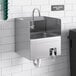 A Regency wall mounted hand sink with knee operated valves and side splashes.