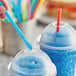 A person holding a Choice Super Jumbo unwrapped straw in a blue drink.