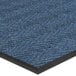 A blue carpet entrance mat with a black border in a chevron pattern.