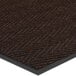 A close-up of a brown Lavex Chevron Rib entrance mat with black trim.