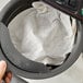 A hand holding a black Bromley tea filter bag.