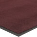 A close-up of a burgundy carpet mat with a black border.