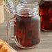 Two glass mason jars filled with Caribou Coffee Daybreak Morning Blend iced coffee on a white background.