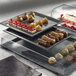 A Solia black slate tray with a variety of desserts on a table.