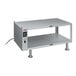 A grey metal Hatco heated shelf on a table with shelves.