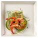 A Solia white square plate with shrimp and lemon slices on it.