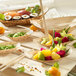 A table with bamboo leaf boat dishes filled with a variety of food.