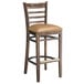 A Lancaster Table & Seating wood ladder back bar stool with light brown vinyl seat.