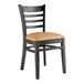 A Lancaster Table & Seating black wood ladder back chair with light brown vinyl seat.