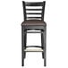 A Lancaster Table & Seating black wood ladder back bar stool with a dark brown vinyl seat.