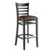 A Lancaster Table & Seating black wood bar stool with a dark brown vinyl seat.