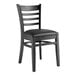 A Lancaster Table & Seating black wooden chair with a black cushion.