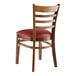 A Lancaster Table & Seating wooden ladder back chair with a burgundy vinyl seat.