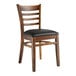 A Lancaster Table & Seating wooden ladder back chair with a black vinyl seat.
