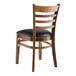 A Lancaster Table & Seating wood ladder back chair with black vinyl seat on a white background.