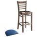 A Lancaster Table & Seating wooden ladder back bar stool with a navy vinyl seat.