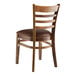 A Lancaster Table & Seating wooden ladder back chair with a dark brown vinyl seat.