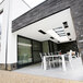 A modern house with a patio table and chairs using a Bromic Heating ceiling recess kit.