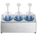 A Steril-Sil stainless steel condiment dispenser kit with blue cylinders and dome top pump lids holding three condiments over plastic cups.