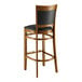 A Lancaster Table & Seating Sofia wood bar stool with black vinyl seat.