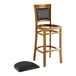 A Lancaster Table & Seating Sofia wood bar stool with a black seat.