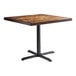 A Lancaster Table & Seating square wooden table with a black cast iron base.