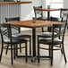 A Lancaster Table & Seating wooden table with a cast iron base and chairs around it.