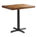 A Lancaster Table & Seating rectangular butcher block table with a cast iron base plate.