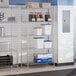 A chrome 5-shelf storage rack with various containers and boxes placed on its shelves.
