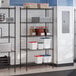 A black epoxy 5-shelf wire shelving unit with 72-inch posts, used for storage in a commercial kitchen setting.
