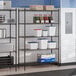 A black epoxy 5-shelf storage rack with various containers and boxes placed on the shelves.