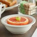 An Acopa ivory stoneware bowl with a grapefruit slice in it.