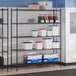 A black epoxy 5-shelf storage rack with various containers and boxes placed on the shelves.