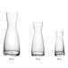 Acopa glass carafes with white caps on a white background.