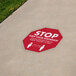A white floor decal with red octagon shape and white text that reads "SOCIAL DISTANCING"