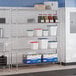 A chrome 5-shelf storage rack with various containers and boxes placed on its shelves.