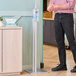 A man using an Advance Tabco hand sanitizer stand in a kitchen.