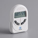 A white Comark digital thermometer and hygrometer on a white surface.
