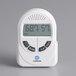 A white Comark digital indoor thermometer and hygrometer on a wall with a screen and buttons.