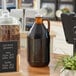 An Acopa amber growler on a table.