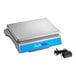 A silver and blue AvaWeigh digital portion scale on a white counter.