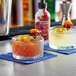 Two glasses of drinks garnished with wild hibiscus flowers on a bar counter.