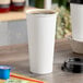 A white Choice paper hot cup of coffee on a table.