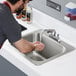 a person washing hands in a sink