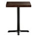 A square wooden table top with an espresso finish and a black cast iron base plate.