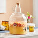 An Acopa glass beverage dispenser filled with fruit juice and fruit.