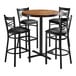 A Lancaster Table & Seating vintage wood butcher block bar table with four black chairs around it.