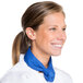 A woman in a white chef's coat with a royal blue neckerchief.