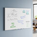 A rectangular wall-mounted melamine whiteboard with an aluminum frame, featuring various notes and drawings.