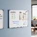 A wall-mounted magnetic whiteboard with an aluminum frame measuring 24 by 18 inches.